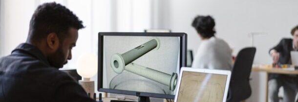 A imagem mostra um designer elaborando uma peça 3D em um software.